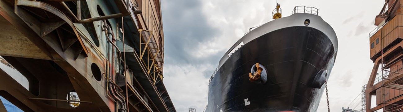 image of large red and black ship offshore on site