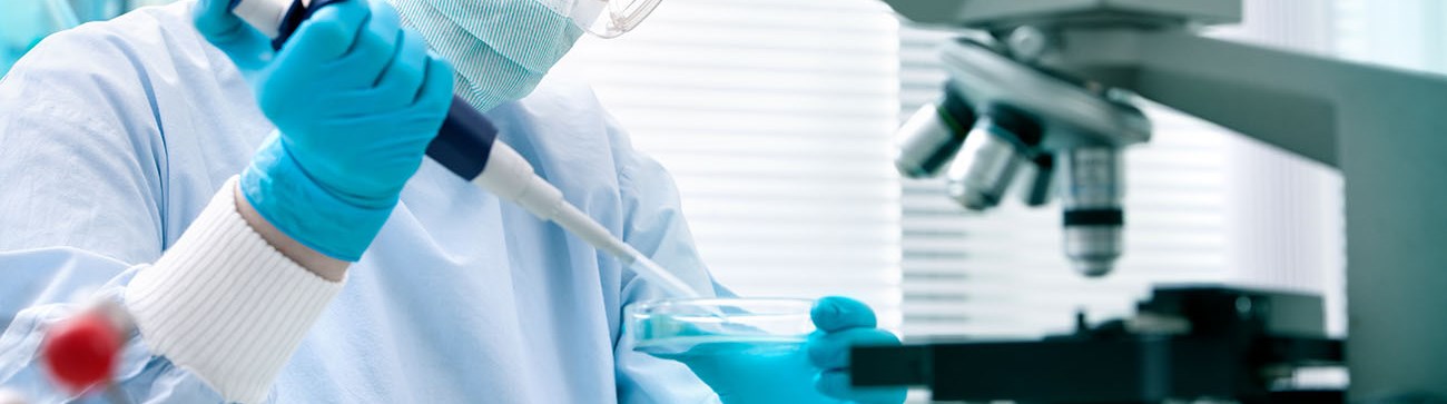 a person carries out laborartory testing and a microscope