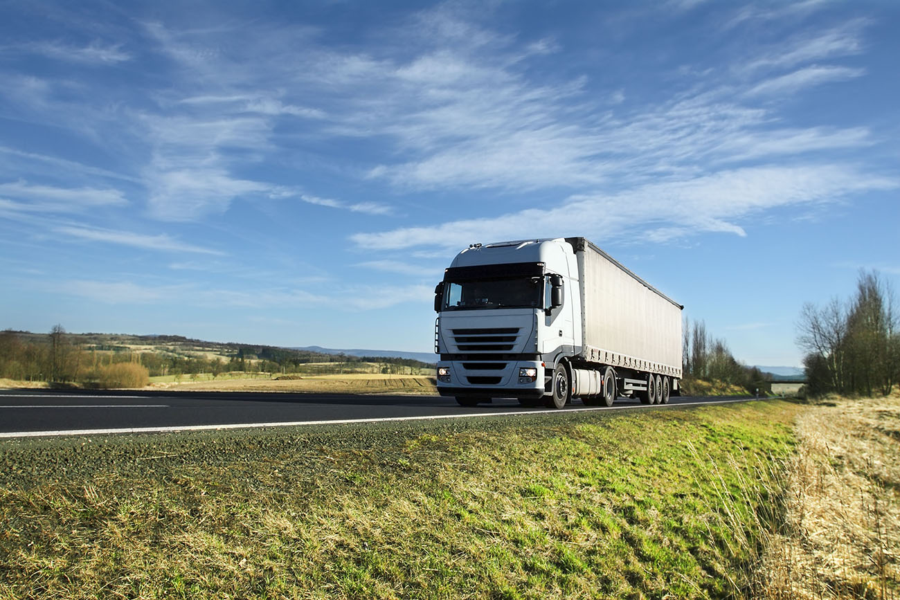 a white lorry travelling along an open country road