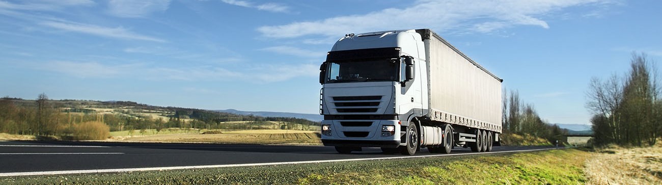 a white lorry travelling along an open country road