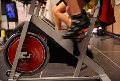 close up of feet operating an exercise spinning bike