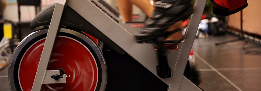 close up of feet operating an exercise spinning bike
