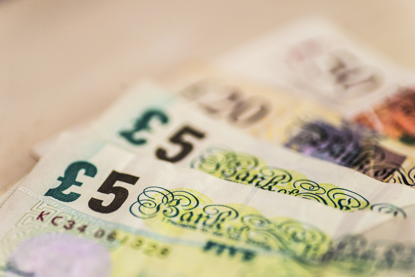 fan of money with two five pound notes in focus
