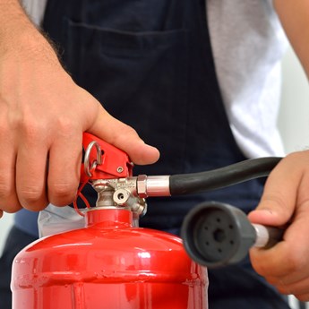 close up of hands holding a fire extinguisher 