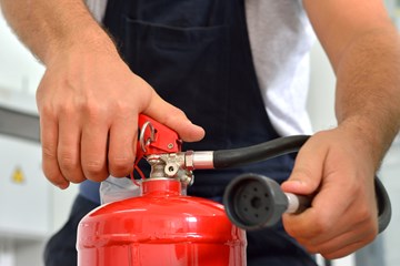 close up of hands holding a fire extinguisher 
