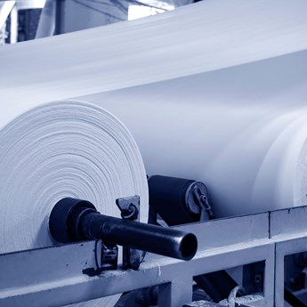 close up of white rolls of material in a factory