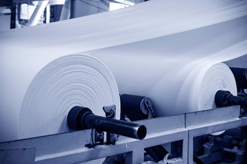 close up of white rolls of material in a factory
