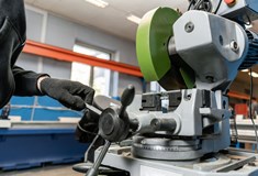 a man wearing black gloves works in a factory