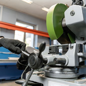 a man wearing black gloves works in a factory