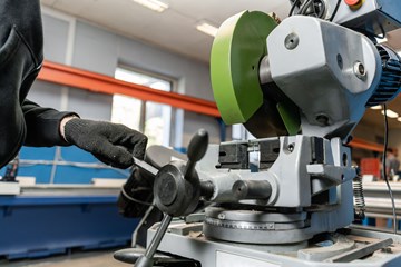 a man wearing black gloves works in a factory
