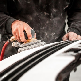 close up of worker sanding down metal