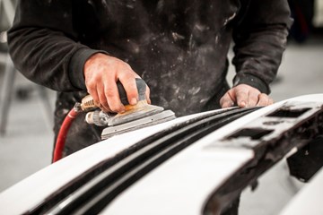 close up of worker sanding down metal