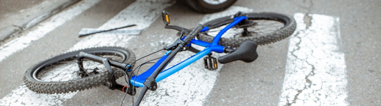 image of a blue bike lying on a zebra crossing
