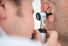 close up of man examing inside an ear