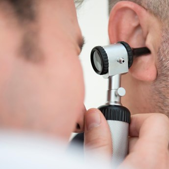 close up of man examing inside an ear