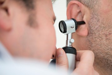 close up of man examing inside an ear