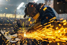 bright orange electric sparks with workman in protective clothing in background